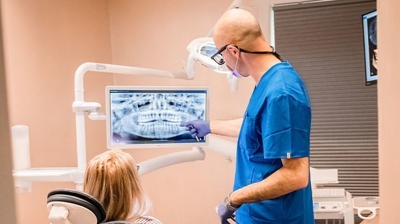 Dentist and patient looking at dental x-rays in office Photo